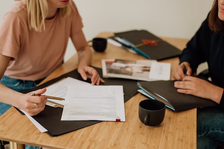 Couple discusses divorce together with shared family lawyer at collaborative meeting table